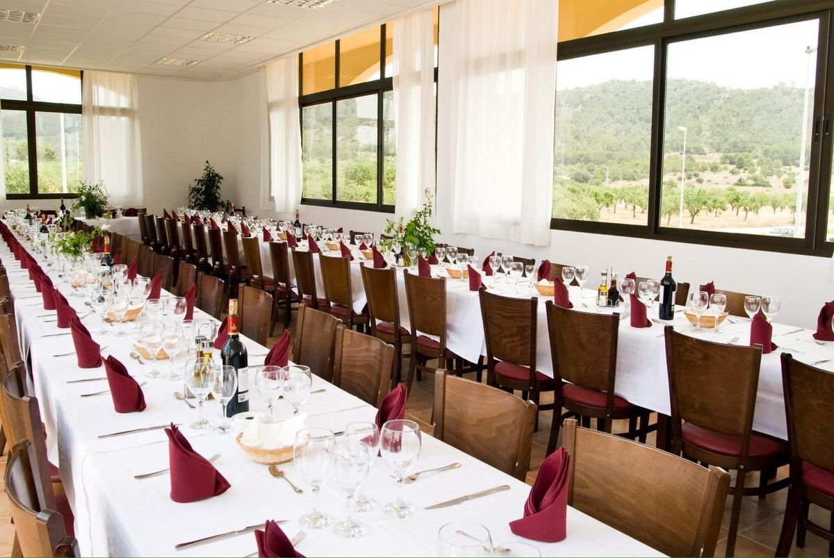 Salón del Gran Buffet preparado para un banquete, con mesas largas, manteles blancos y servilletas granate