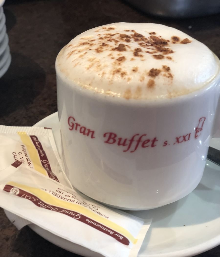 Capuchino en taza con el logo de Gran Buffet s.XXI