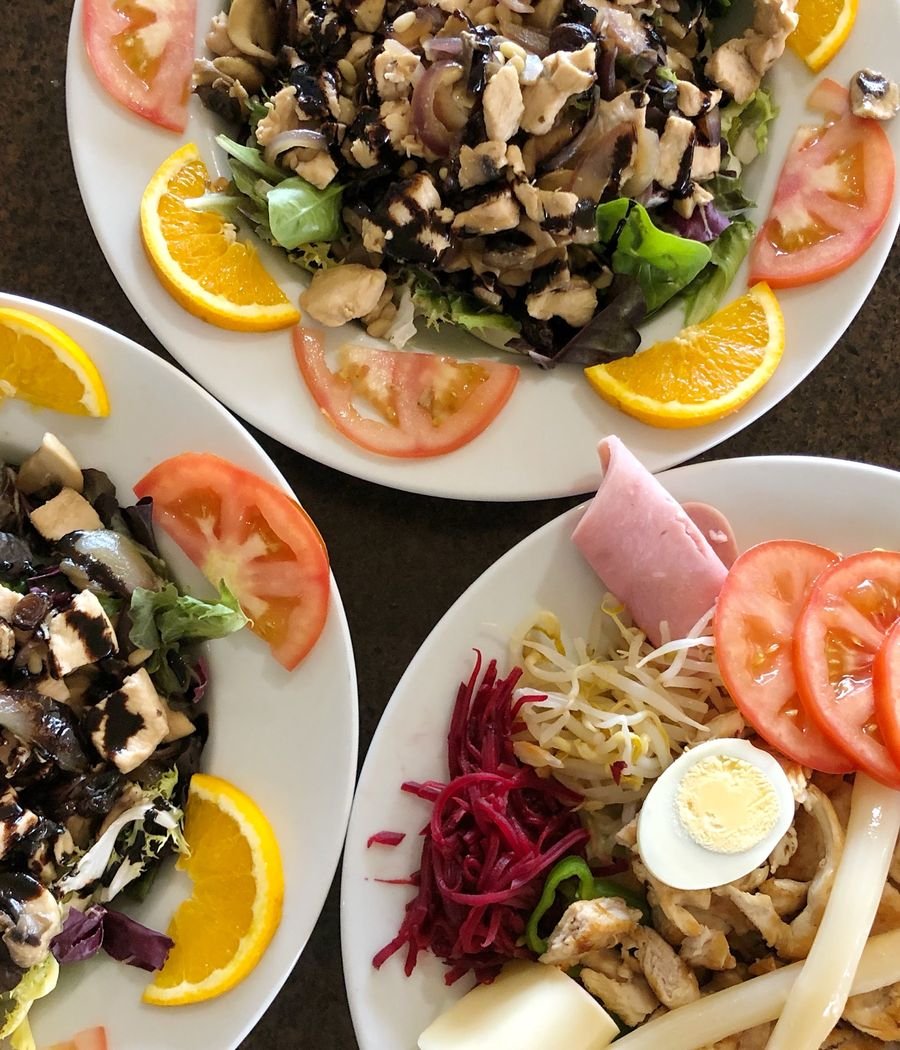 Dos platos de ensalada con setas, naranja, tomate y huevo