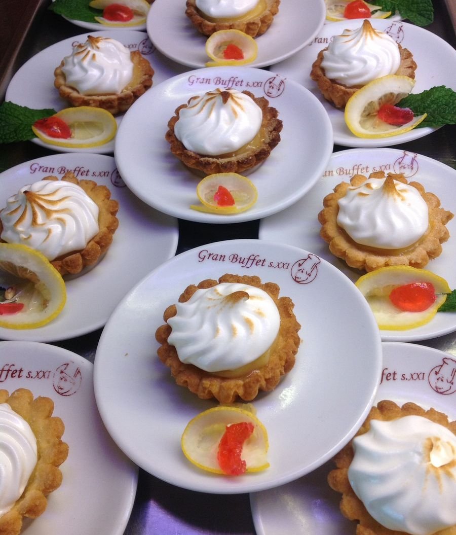 Tartaletas de limón con merengue servidas en platos con el logo de Gran Buffet